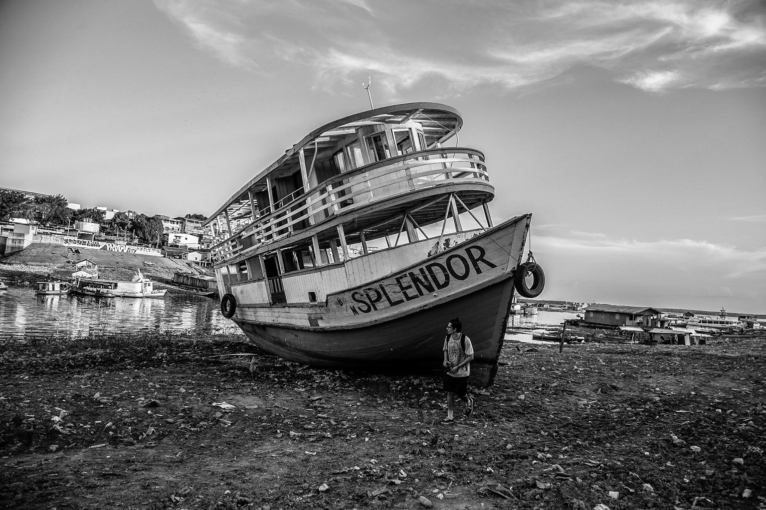 Barco de madeira à margem do rio em preto e branco