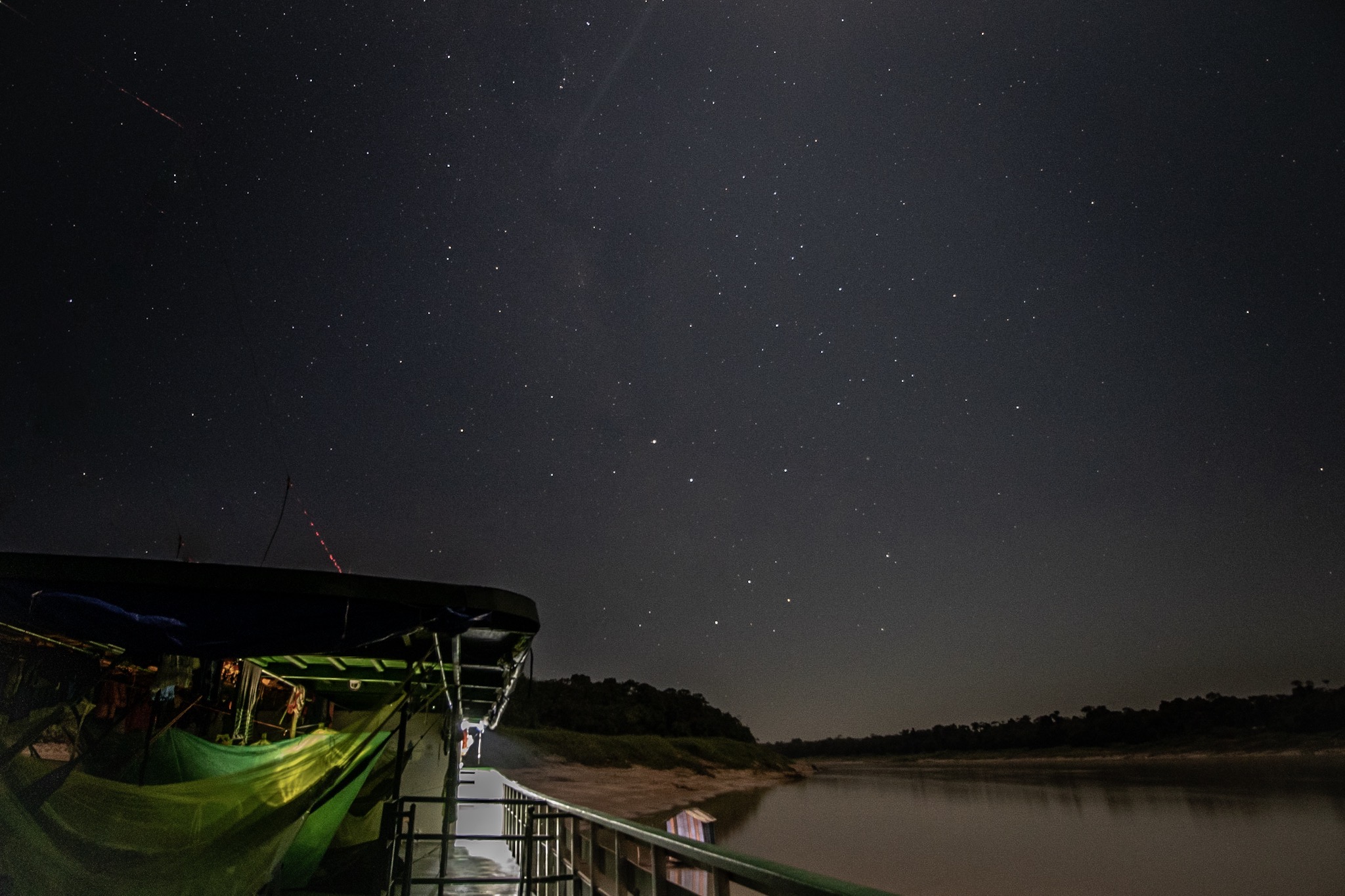 Céu estrelado sobre o rio com barco em primeiro plano